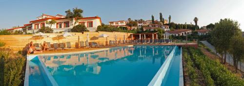 una gran piscina con sillas y una casa en Belvedere Aeolis Hotel, en Mithimna