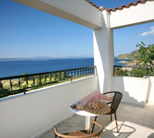 a balcony with a table and chairs and the ocean at Belvedere Aeolis Hotel in Mithymna