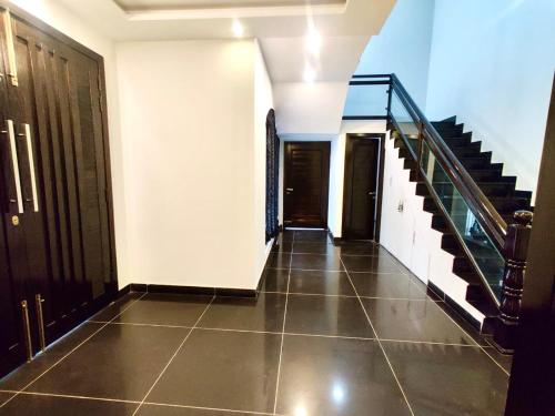 an empty hallway with a staircase and a tiled floor at Luxury Villa - 1 Kanal Furnished 5 bedrooms , DHA Phase 6 in Lahore