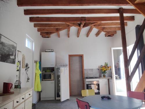 une cuisine avec une table et des chaises dans une pièce dans l'établissement Petite maison atypique, à Bouillac