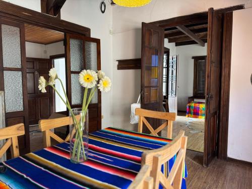a dining room with a table with flowers in a vase at La Casa de Ignacia in Estación Ramallo