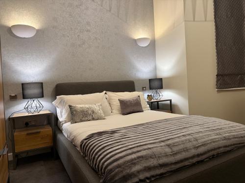 a bedroom with a large bed with two lamps at BAYCROFT House in London