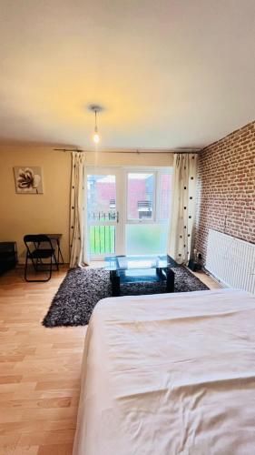 a bedroom with a bed and a brick wall at Convenient Retreat Rooms in Reading