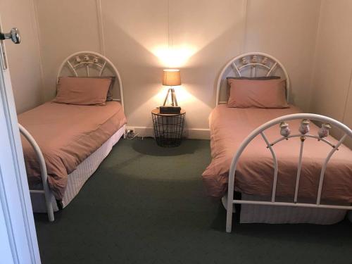 deux lits côte à côte dans une pièce dans l'établissement Country Style Cottage, à Ouyen