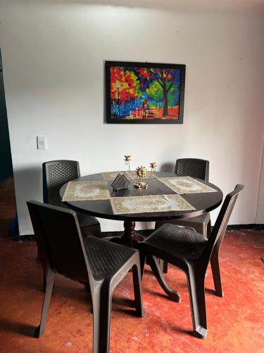 a dining room table with chairs and a painting on the wall at Pinck House in Circasia