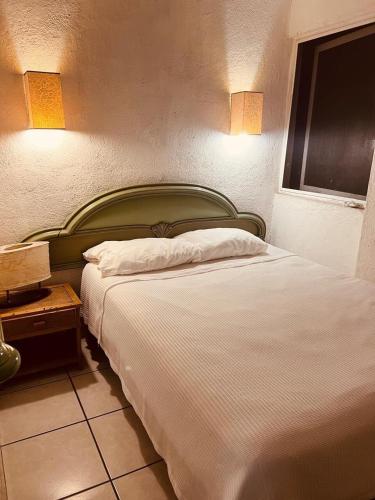 a bedroom with a bed with a green headboard at Cozy Marbella suits 2 bed 2 bath in Puerto Vallarta