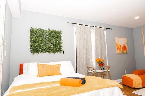 a bedroom with a bed with orange pillows at The Philly Factory! in Philadelphia