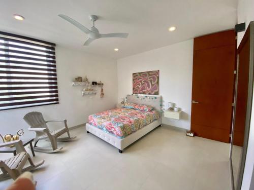 a bedroom with a bed and a ceiling fan at Alexis House in Mérida