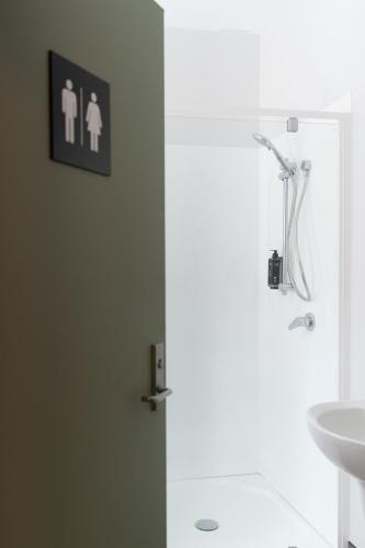 a bathroom with a shower and a toilet and a sink at Haka House Christchurch in Christchurch