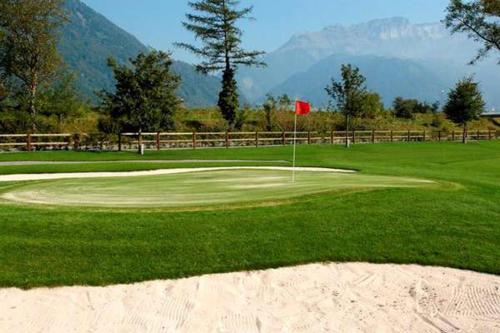 a golf course with a flag on a green at Perle am Vierwaldstättersee in Fluelen