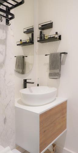 a white bathroom with a sink and a mirror at Loft -Skyline view- Rooftop pool, gym, bbq & more in Mexico City