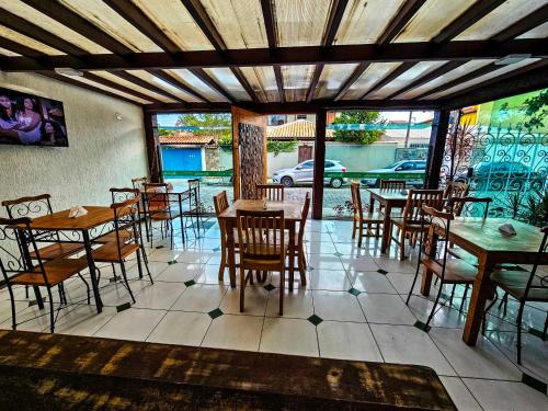 Un restaurante con mesas y sillas en una sala. en Pousada Abacateiro, en Búzios