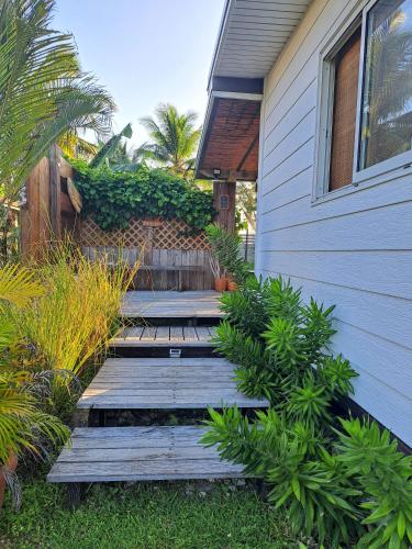 a house with a wooden walkway next to a building at Breeze Ocean Bungalow Moorea in Moorea