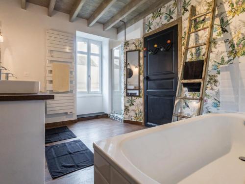 une salle de bain avec une baignoire et un lavabo dans l'établissement Gîte familial avec piscine chauffée à Legé - FR-1-306-1296, à Legé