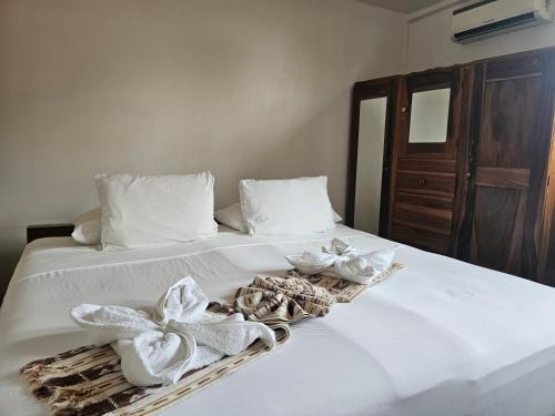 a white bed with towels and towels on it at Nuestra Casa in San Juan del Sur