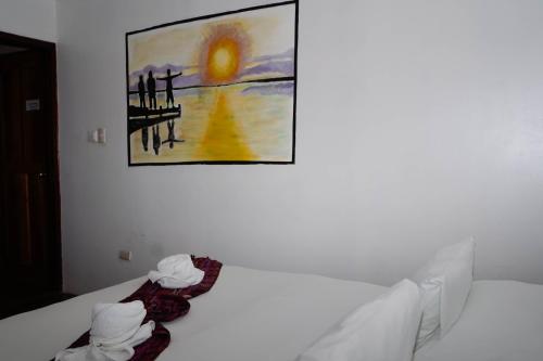 a bedroom with a bed with a painting on the wall at Nuestra Casa in San Juan del Sur