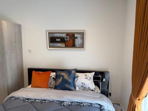 a bedroom with a bed with pillows on it at Loxwood Apartment Tetteh Quashie Accra Ghana in Accra