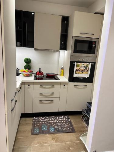 a kitchen with white cabinets and a stove top oven at Solaris Apartment at Osu Ghana in Accra