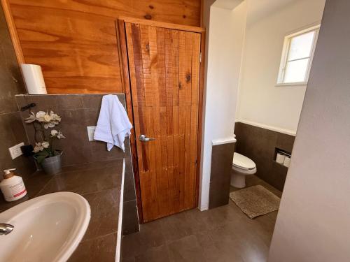 a bathroom with a sink and a wooden door at Estudio Terraza - Todos Santos - Centro in Todos Santos