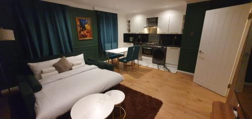 a hotel room with a bed and a kitchen at Luxurious Flat 19min from London, 7min to station in Harrow