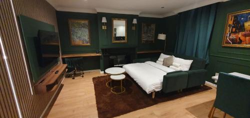 a bedroom with a bed in a green room at Luxurious Flat 19min from London, 7min to station in Harrow