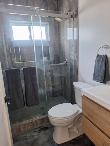 a bathroom with a toilet and a glass shower at Beautiful and cosy home in Azusa