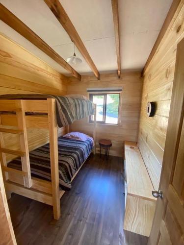 Un dormitorio con dos literas en una cabaña. en Cabaña AC Llifén, en llifen