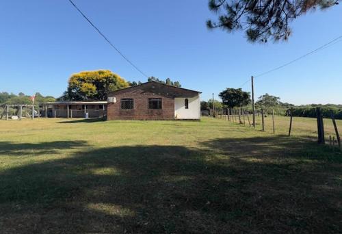a small building in the middle of a field at Chácara Revoar in São Gabriel