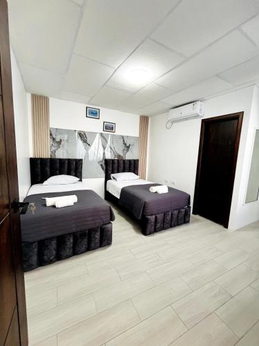 a room with two beds in a room with a door at Blue house in Puerto Ayora