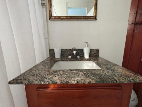 a bathroom with a sink and a mirror at Cozy Apartment w/Ocean View, Pool & Beach Access in Montego Bay