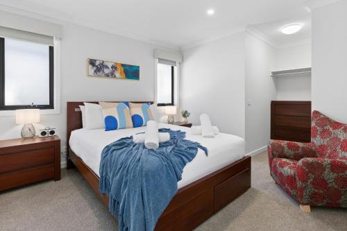 ein Schlafzimmer mit einem Bett mit einer blauen Decke darauf in der Unterkunft Pengana Beach Retreat Mornington Peninsula in Rosebud