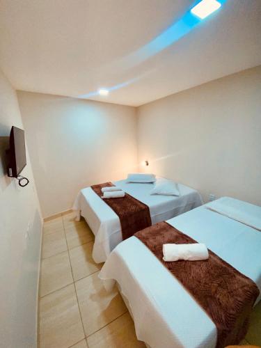 a hotel room with two beds and a tv at Pousada Iracema Charme in Fortaleza