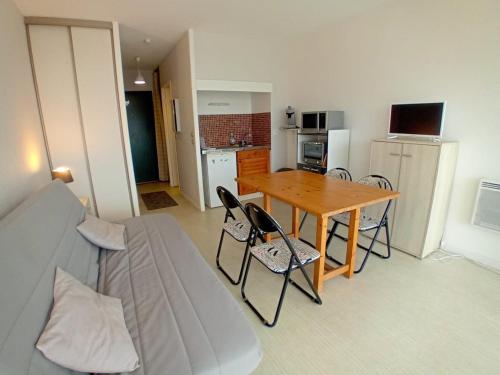 un salon avec un canapé et une table avec des chaises dans l'établissement Studio avec terrasse et parking à deux pas des plages - FR-1-239-563, à Capbreton