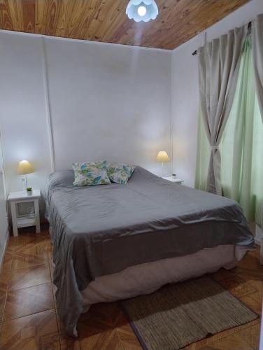 una camera da letto con un letto, due tavoli e due lampade di Altos Coirones Cabañas a Potrerillos
