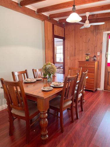 a dining room with a wooden table and chairs at Little creek farm stay in Norton Summit