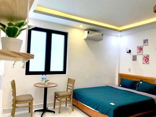a bedroom with a bed and a table and chairs at Win House Huế in Thôn Dương Phẩm