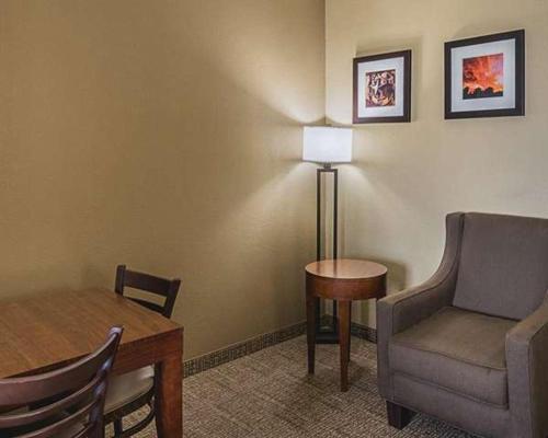 a living room with a chair and a table and a lamp at Comfort Inn in Midland