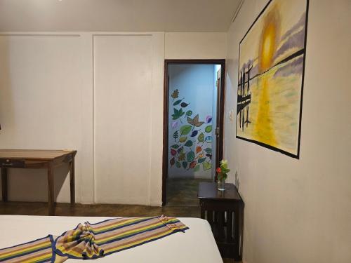 a bedroom with a bed and a painting on the wall at Nuestra Casa in San Juan del Sur