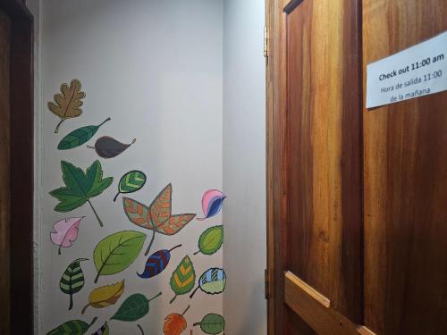 a hallway with a wall with leaves painted on it at Nuestra Casa in San Juan del Sur