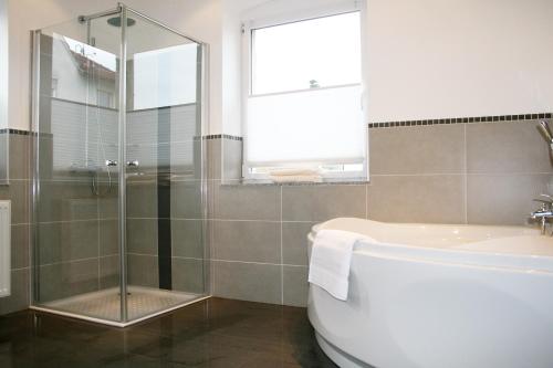 a bathroom with a shower and a tub and a sink at Ferienwohnungen Julia Volkach in Volkach