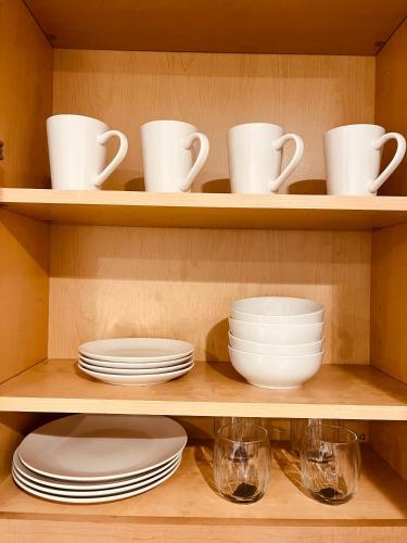 a shelf with plates and cups and dishes on it at Cozy 2-BR Retreat in Kingman, AZ in Kingman