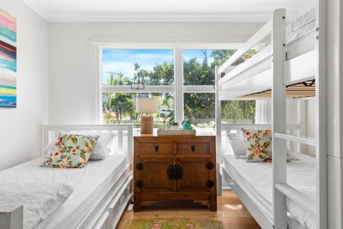 a bedroom with two bunk beds and a window at Kirby's Berrara Beach House in Berrara