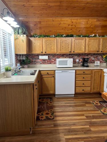 a kitchen with wooden cabinets and a white microwave at Cherokee Cabin-Cave Run Lake and Cliff Views-Red River Gorge in Big Woods