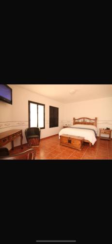 a bedroom with a large bed and a table at Villa villar in Querétaro