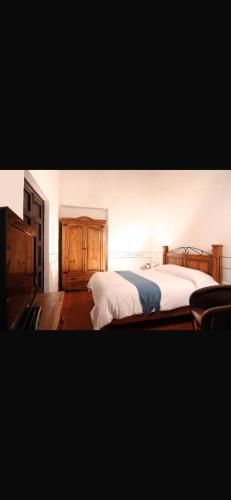 a bedroom with two beds and wooden cabinets at Villa villar in Querétaro