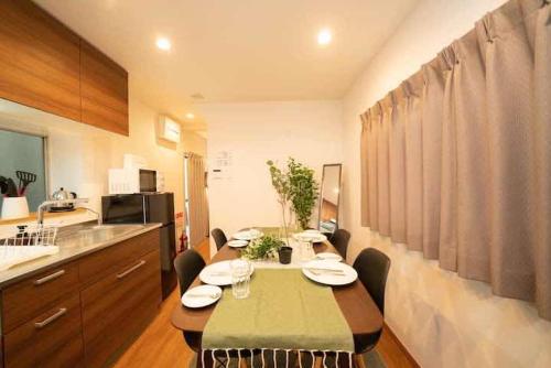een keuken met een tafel en stoelen in een kamer bij Shin-Nakano House in Tokyo