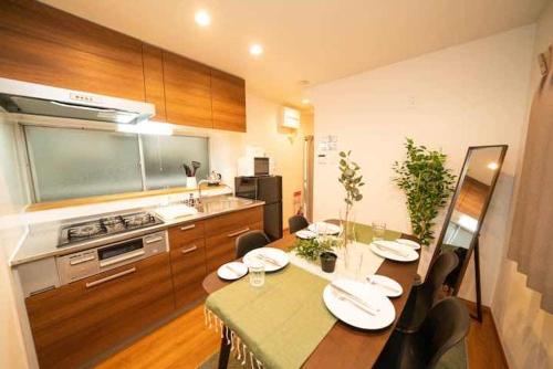 a kitchen with a dining table and a kitchen with a stove at Shin-Nakano House in Tokyo