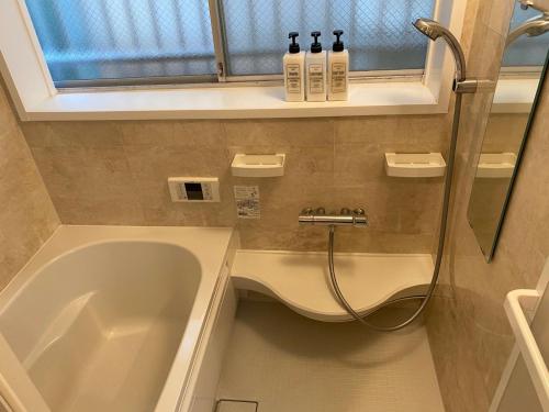 a bathroom with a bath tub and a sink at Shin-Nakano House in Tokyo