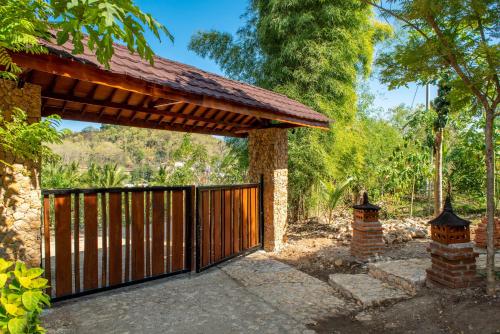 an entrance to a wooden gate with a roof at Golo Nuk in Komodo Labuan Bajo Airport