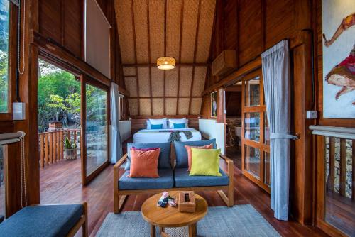 a bedroom in a tiny house with a bed and a table at Golo Nuk in Komodo Labuan Bajo Airport